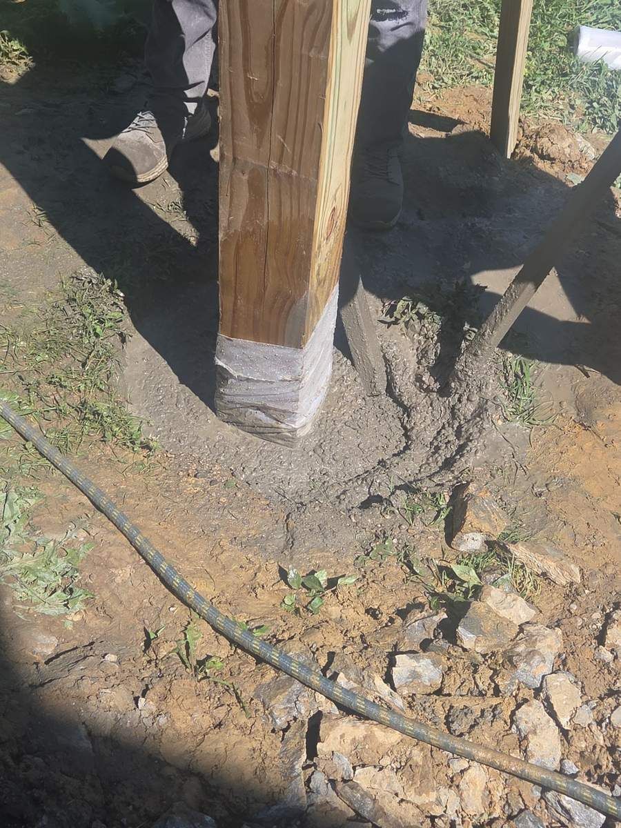 Pressure-treated 6x6 deck post set in a concrete footing