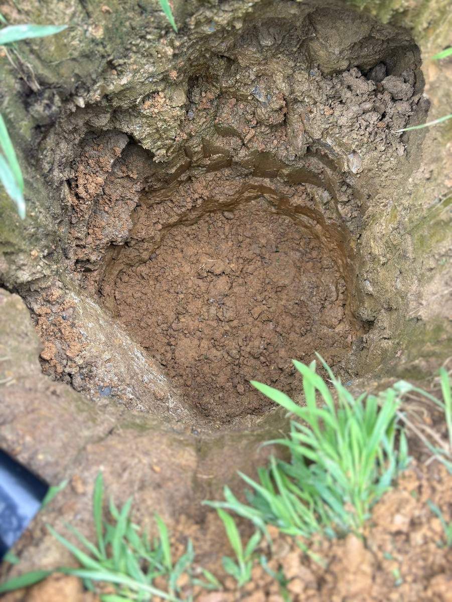 Freshly dug round footing hole for a deck post