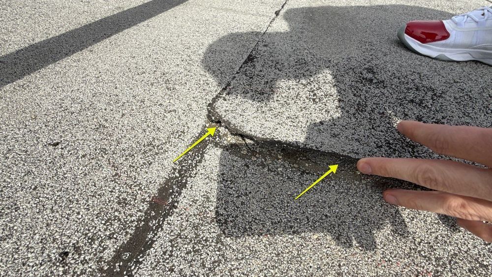 Inspector lifting a delaminated modified bitumen roof seam