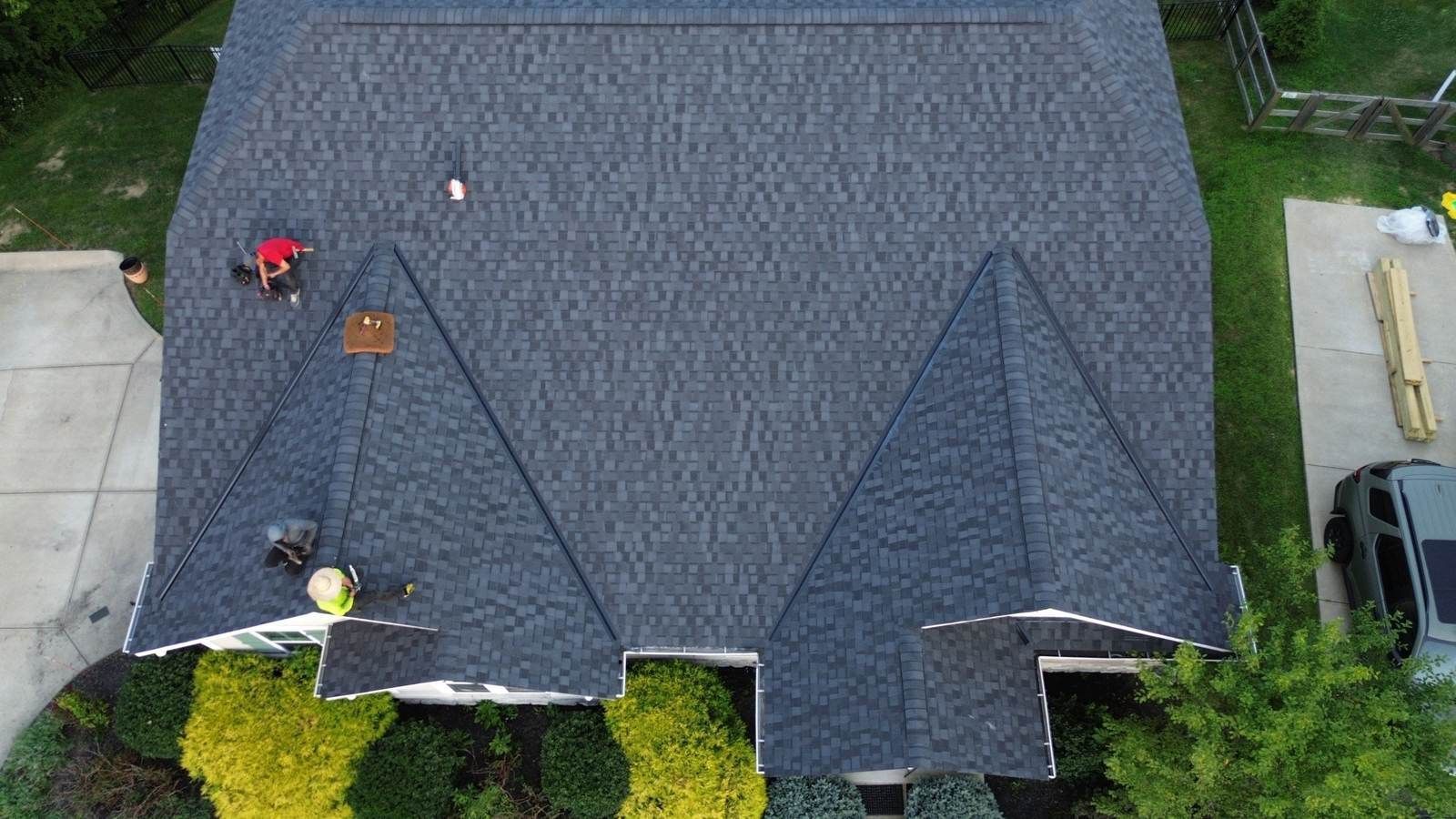 Overhead drone view of Fortress crew finishing a new black shingle roof on an Independence, KY home