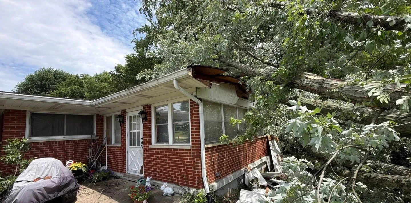 Front of a Florence, KY home with tree damage on the right side of the roof