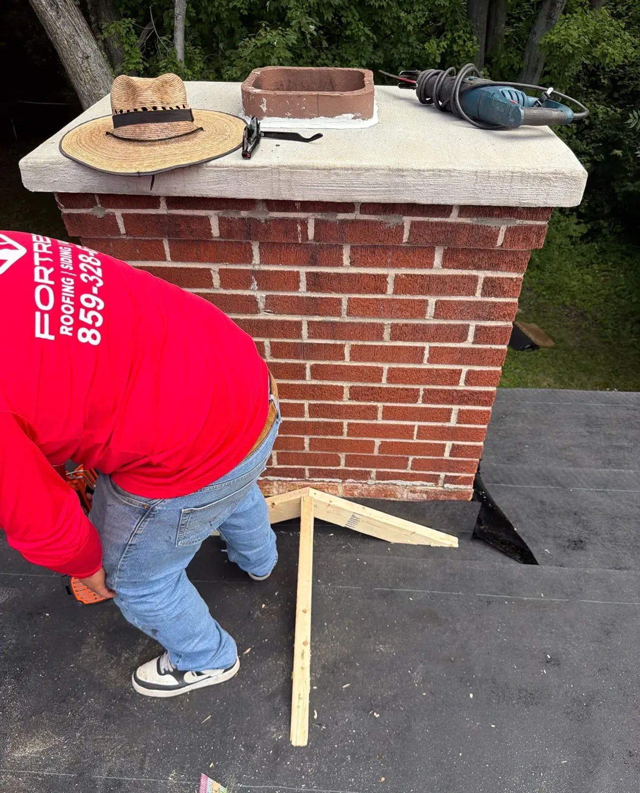 Fortress roofer framing a new chimney cricket during a Florence, KY roof replacement