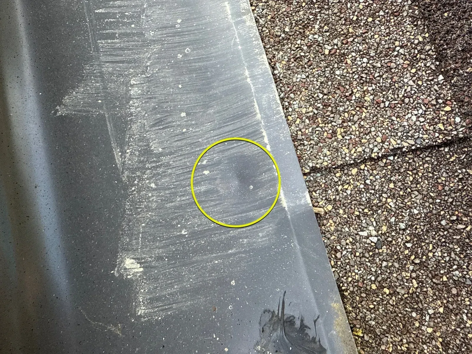 Circled hail impact on metal flashing during a Florence, KY roof inspection