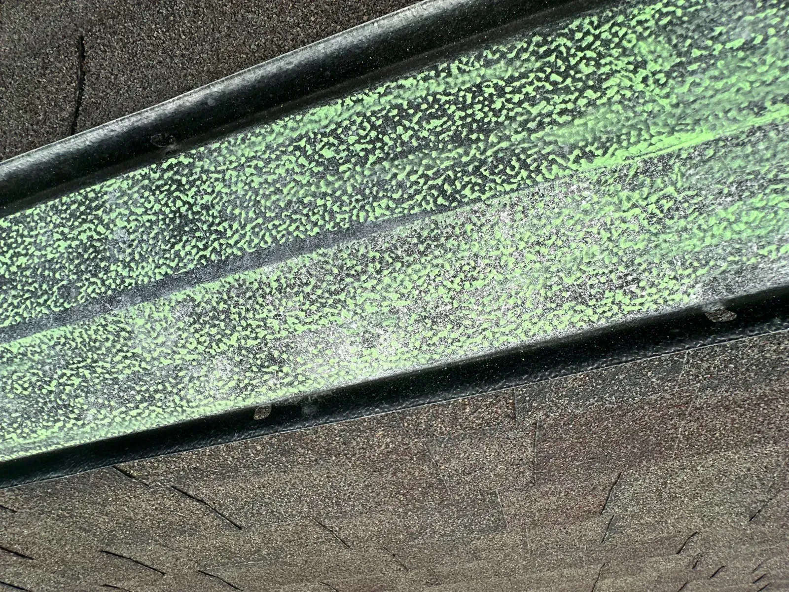 Green chalk marking hail hits along metal ridge flashing on a Florence, KY roof