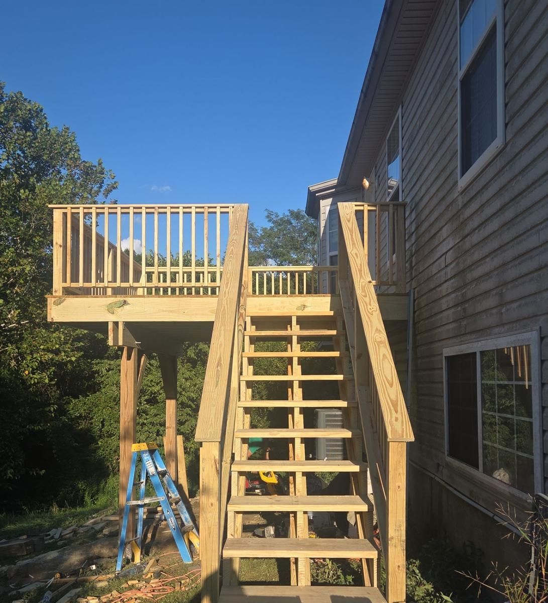 New pressure-treated deck stairs with handrails leading up to a finished elevated deck