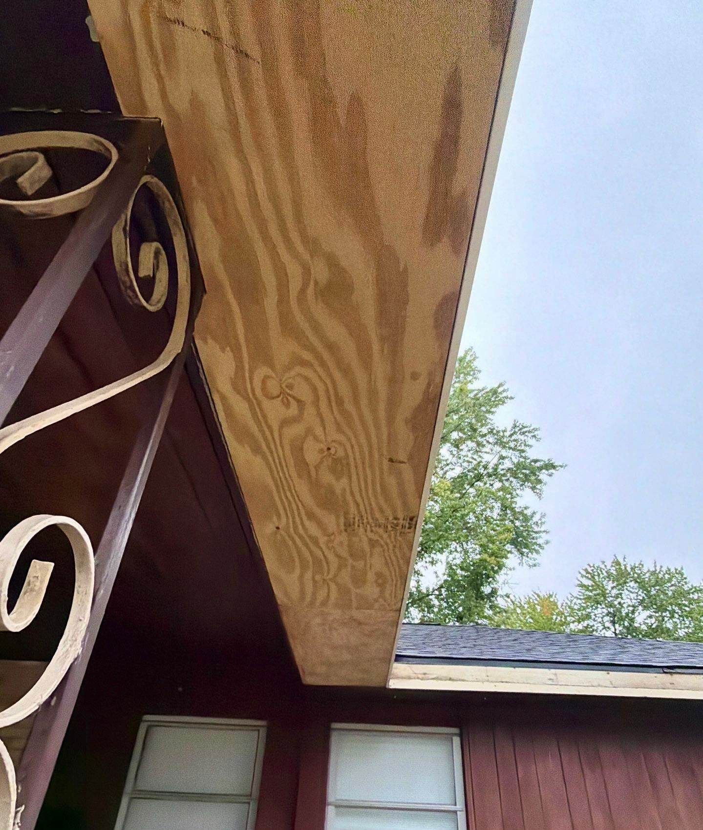 New plywood soffit installed under a carport overhang, seen from below