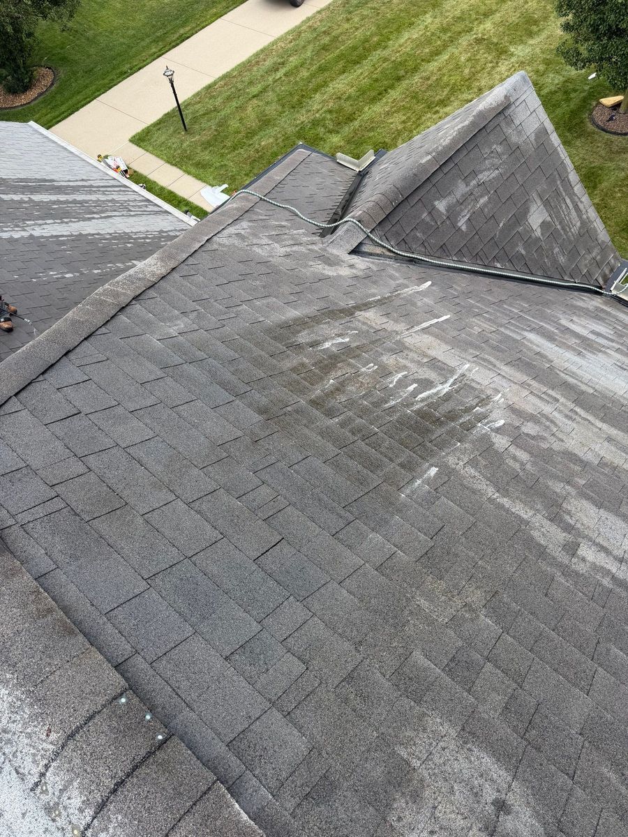 Roof shingles mid-treatment during soft washing