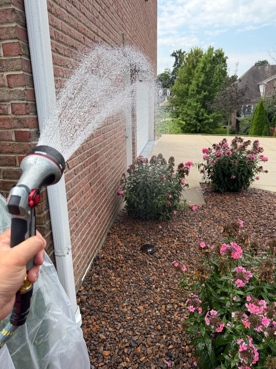 Rinsing flower beds to protect plants during roof soft washing
