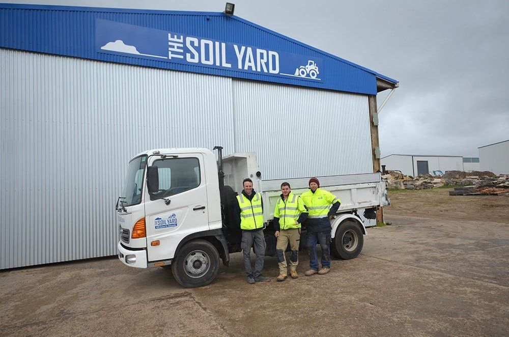 Three People in Safety Vests Stand by a White Dump Truck — The Soil Yard in Delacombe, VIC
