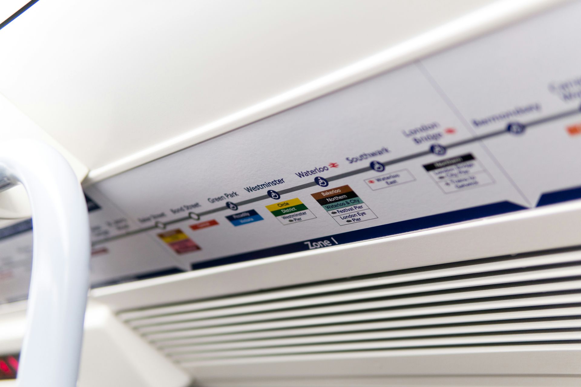 Close-up of an airplane interior emergency instruction panel above the window and vent.