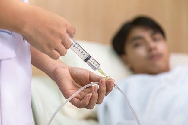 A Nurse Is Giving an Injection to A Patient in A Hospital Bed A Nurse Is Giving an Injection to A Patient in A Hospital Bed