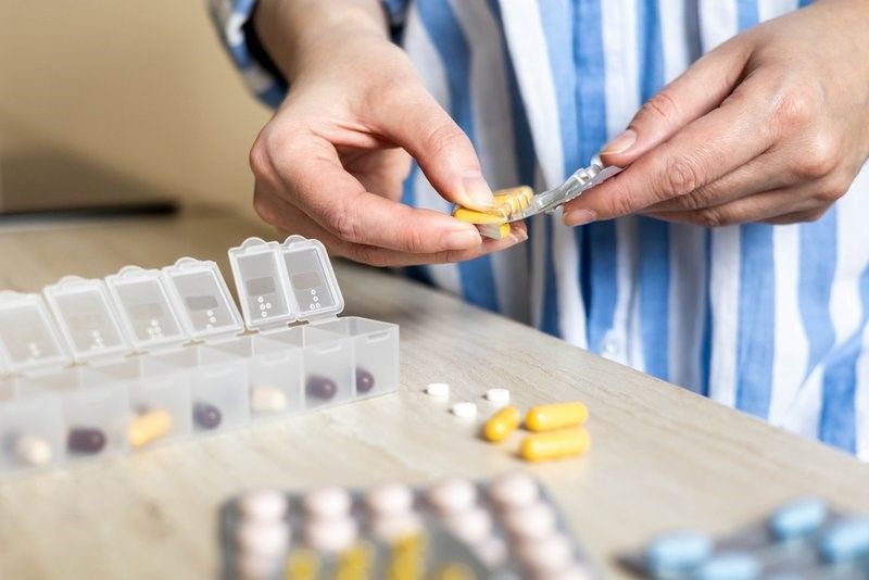 A Woman Is Taking a Pill out Of a Pill Box. A Woman Is Taking a Pill out Of a Pill Box.