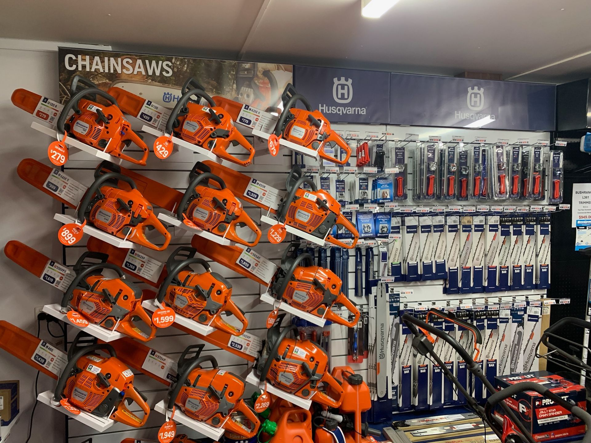 A Display of Orange Husqvarna Chainsaws in a Store — M.M & Mechanical in Dubbo, NSW