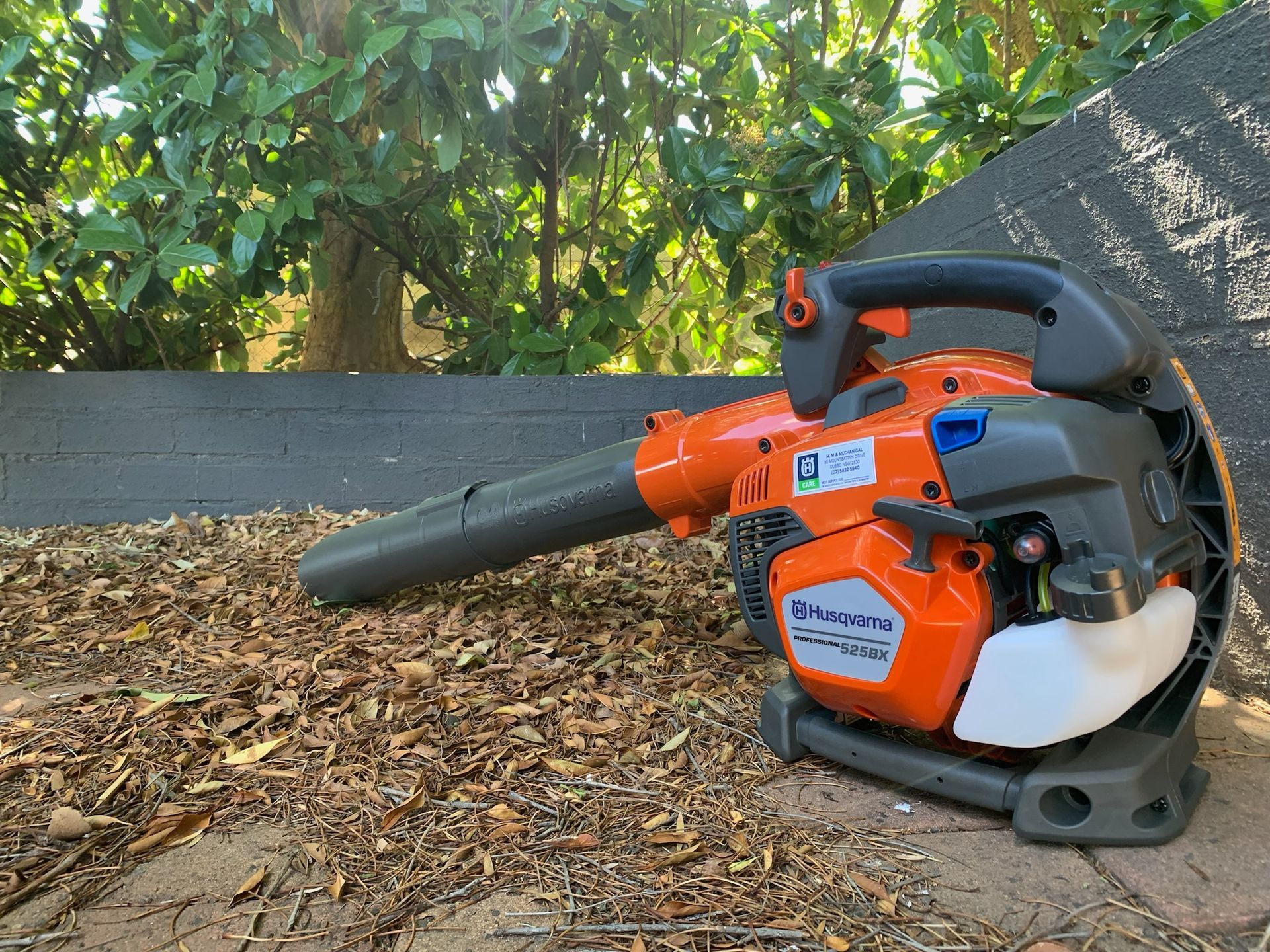 Orange Husqvarna Leaf Blower on a Tree Stump — M.M & Mechanical in Dubbo, NSW