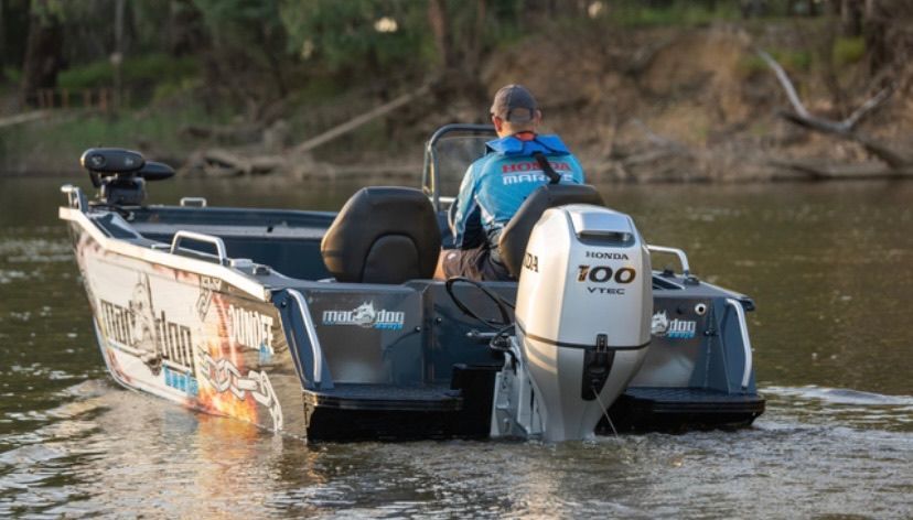 Person driving a motorboat on a river. The boat is grey with an outboard motor— M.M & Mechanical in Dubbo, NSW