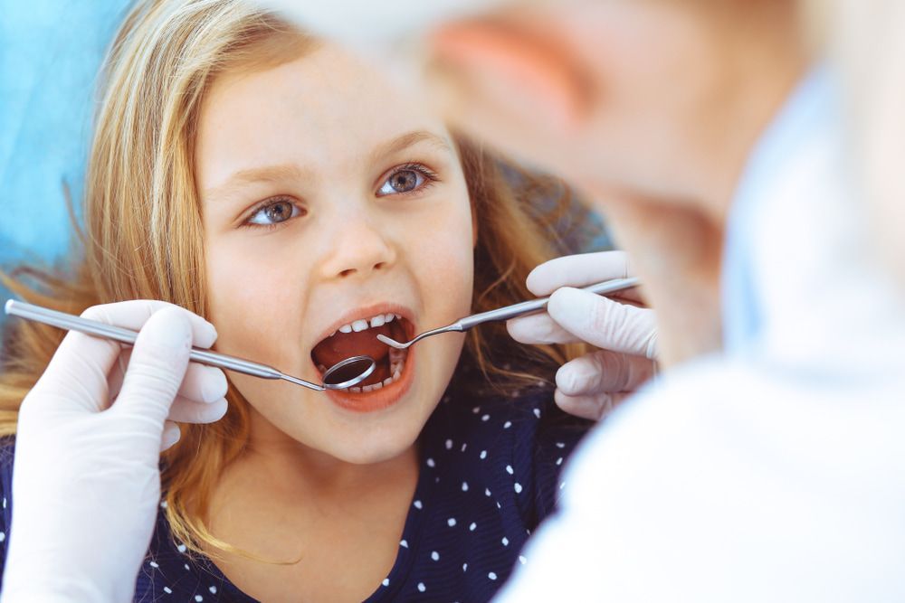 Little Girl Sitting In Dental Chair During Oral Check Up — Dental Services in Gracemere, QLD
