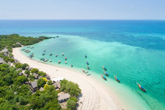 Aerial view of a white-sand Zanzibar beach with boats on turquoise water