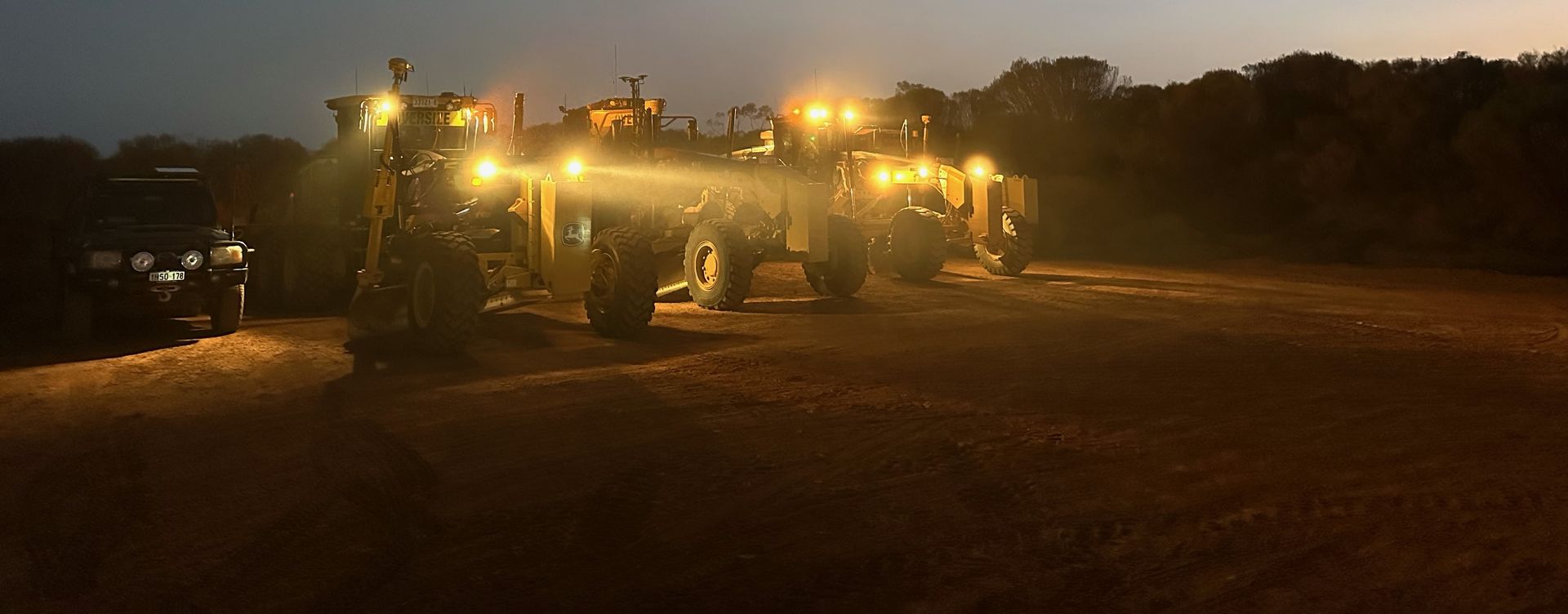 A yellow bulldozer is driving down a dirt road.