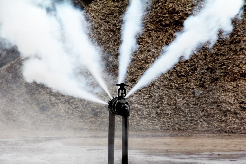 Smoke is Coming Out of a Pipe in Front of a Pile of Wood — Mainline Plumbing & Civil Pty Ltd In Parkes, NSW