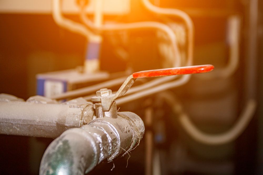 A Close Up of a Red Valve on a Pipe in a Factory — Mainline Plumbing & Civil Pty Ltd In Mudgee, NSW