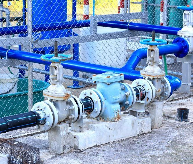 A Bunch of Blue Pipes and Valves Are Sitting on Top of a Concrete Platform — Mainline Plumbing & Civil Pty Ltd In Bourke, NSW