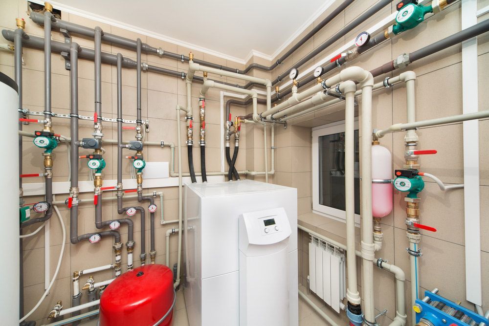 A Close Up of a Row of White Pipes Attached to a Wall — Mainline Plumbing & Civil Pty Ltd In Gilgandra, NSW