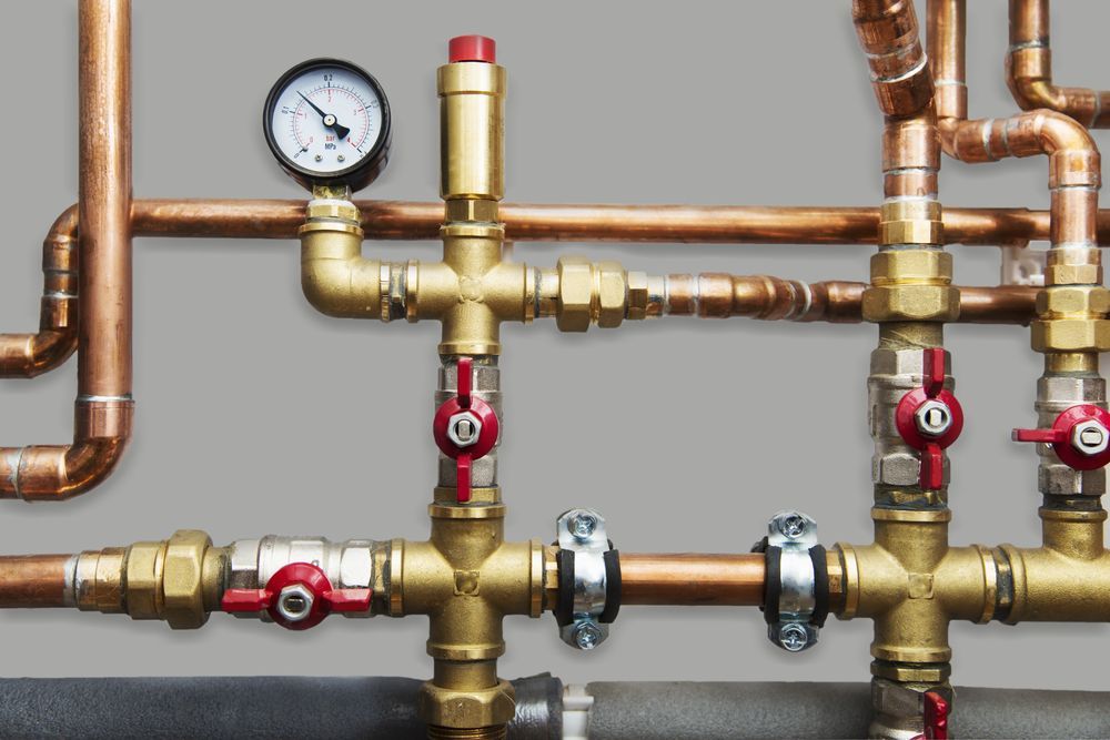 A Close Up of Copper Pipes With a Gauge on Top — Mainline Plumbing & Civil Pty Ltd In Orange, NSW