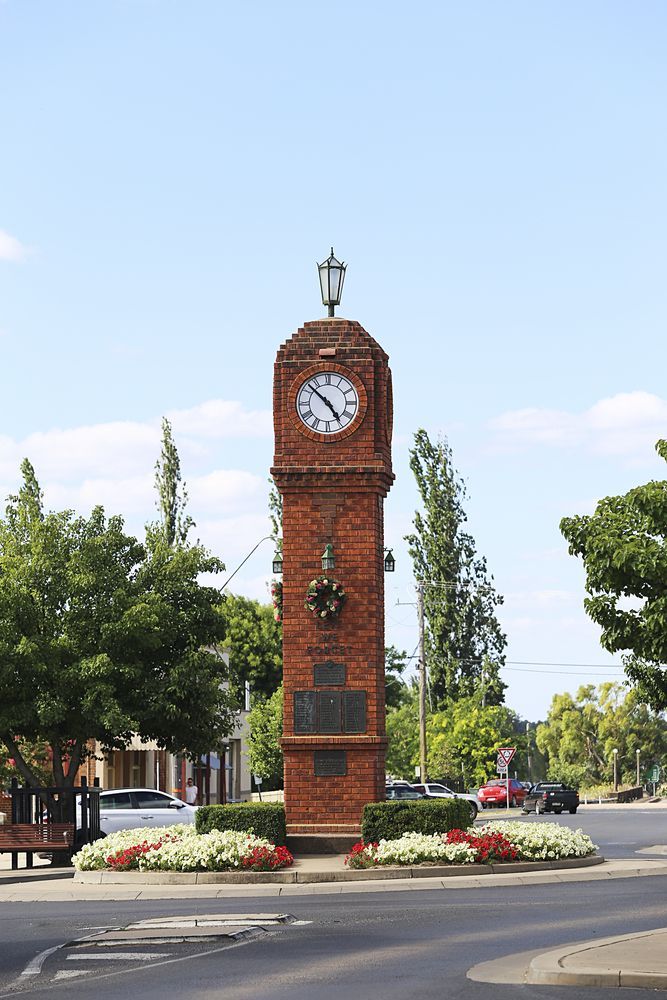 A Brick Clock Tower With A Clock On Top Of It — Mainline Plumbing & Civil Pty Ltd In Mudgee, NSW