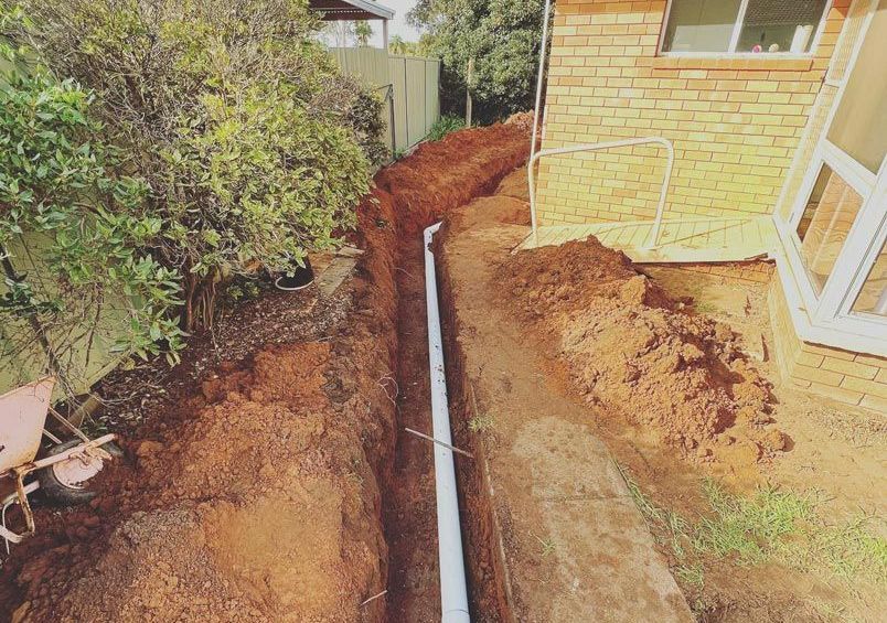 Plumber Fixing Piping Outside — Mainline Plumbing & Civil Pty Ltd In Dubbo, NSW