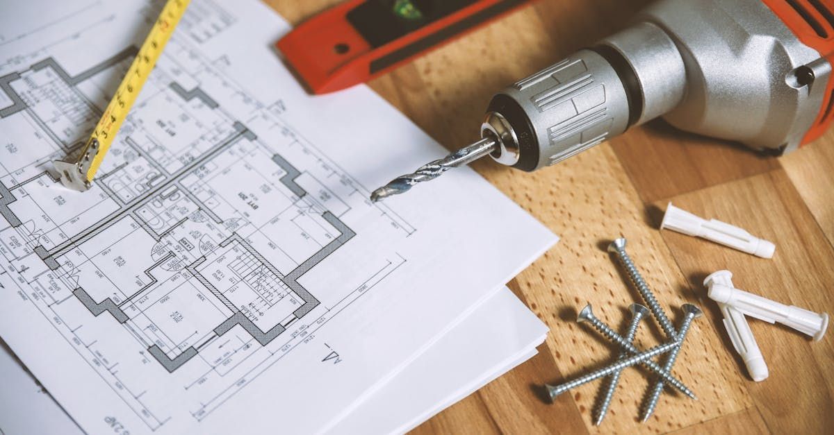A Drill is Sitting on Top of a Blueprint on a Wooden Table — Mainline Plumbing & Civil Pty Ltd In Dubbo, NSW