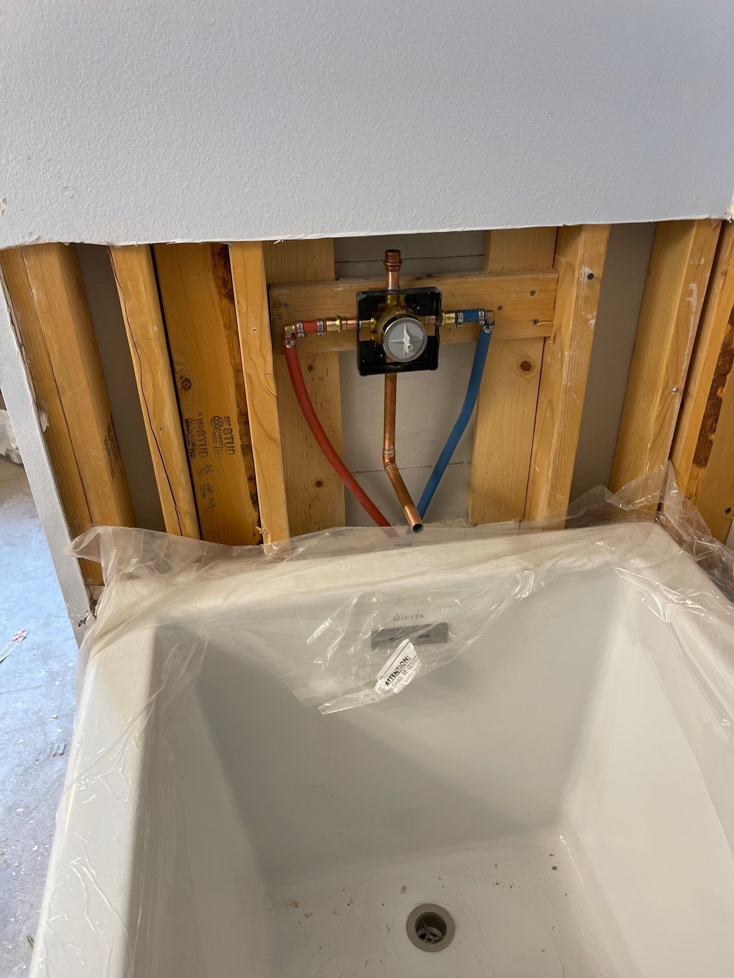 Bathroom sink under construction with exposed plumbing and partially installed vanity.
