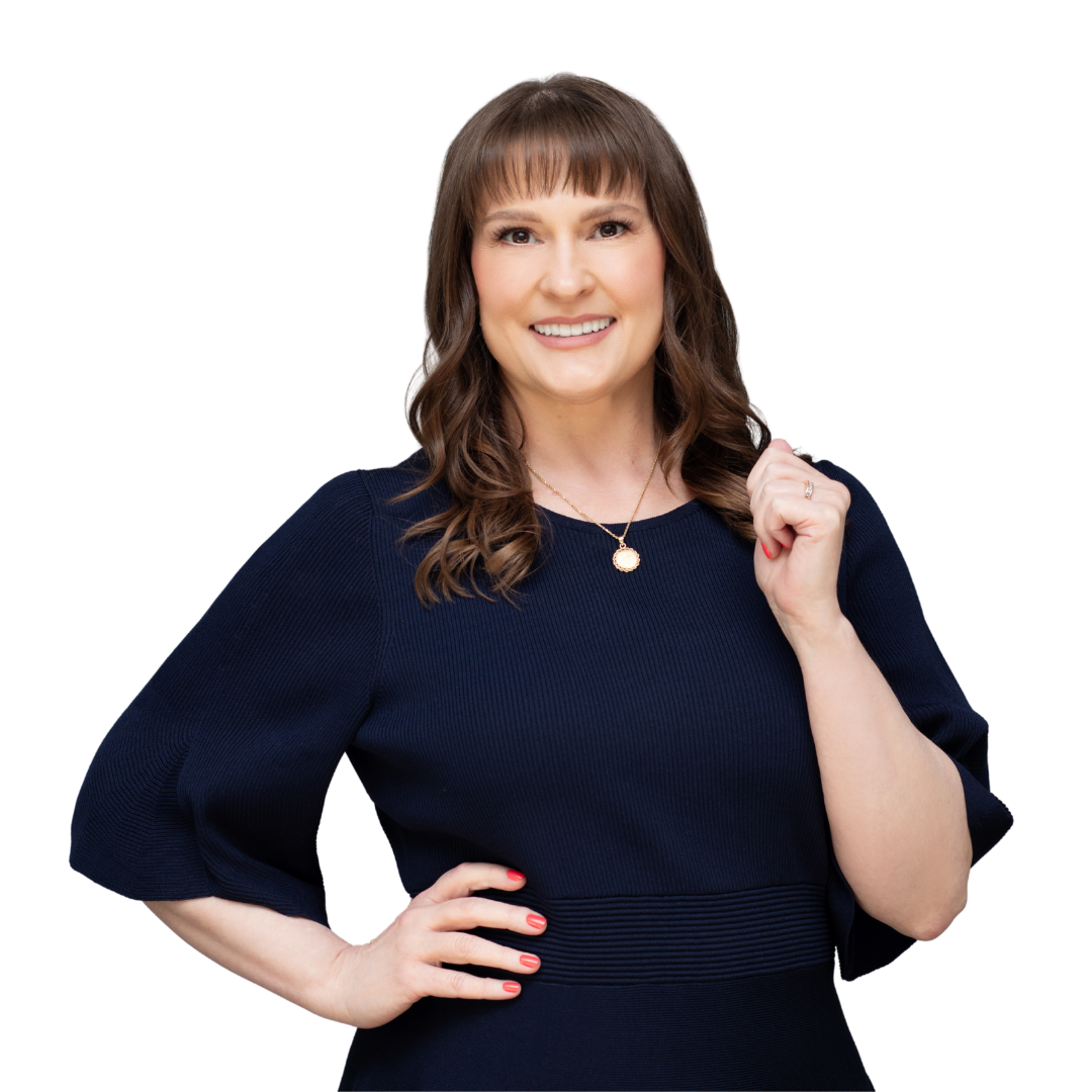 Woman with brown hair in a navy blue dress, smiling, hand on hip, holding her ear.
