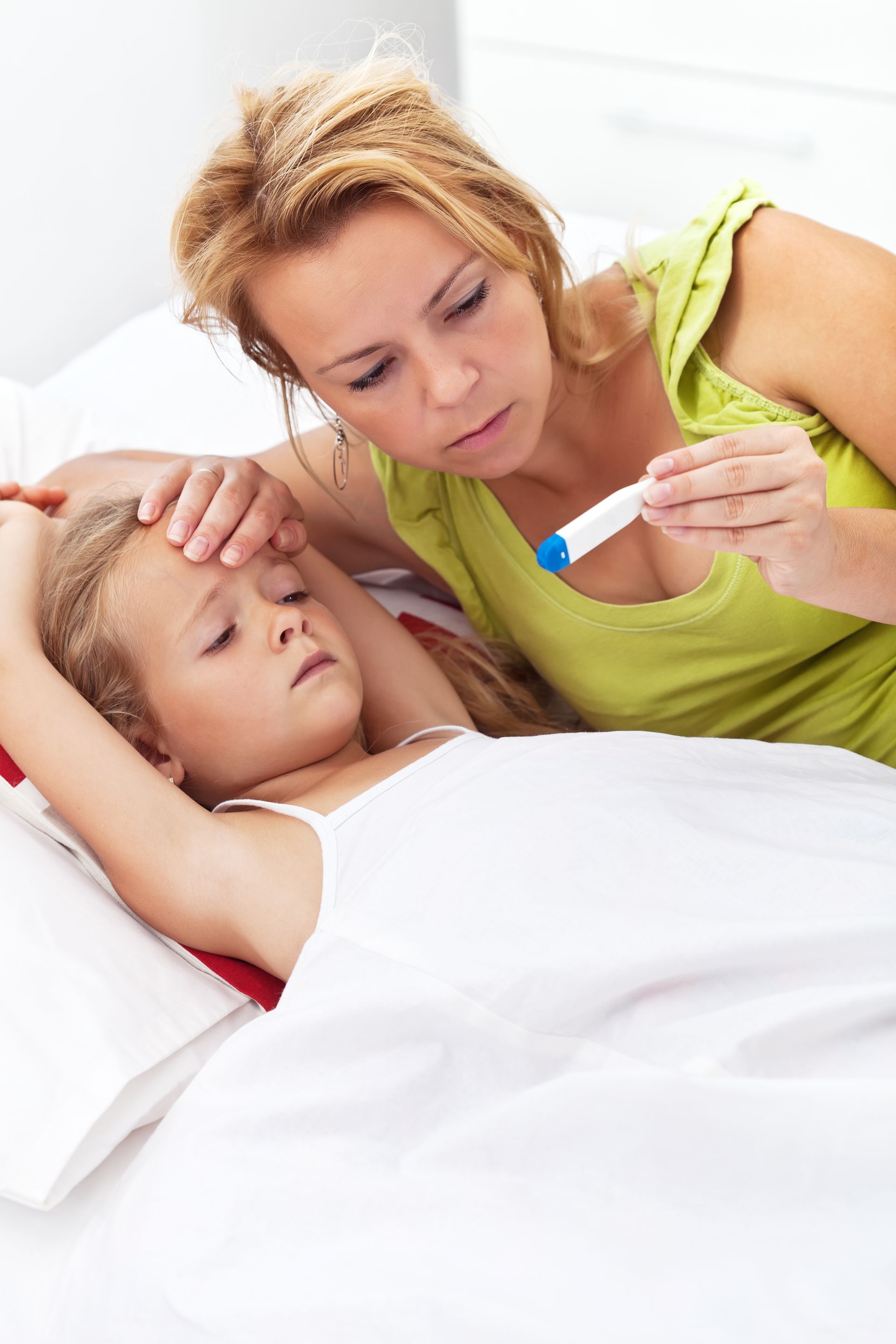A woman is taking a child 's temperature with a thermometer.