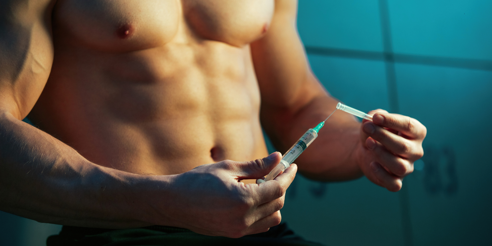 Muscular torso holding a syringe beside a hand, suggesting a steroid injection against a blue wall