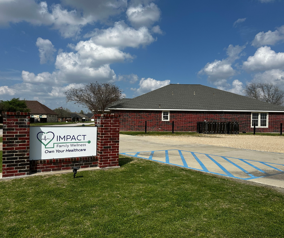Sign for Impact Family Health clinic with brick building and blue sky.