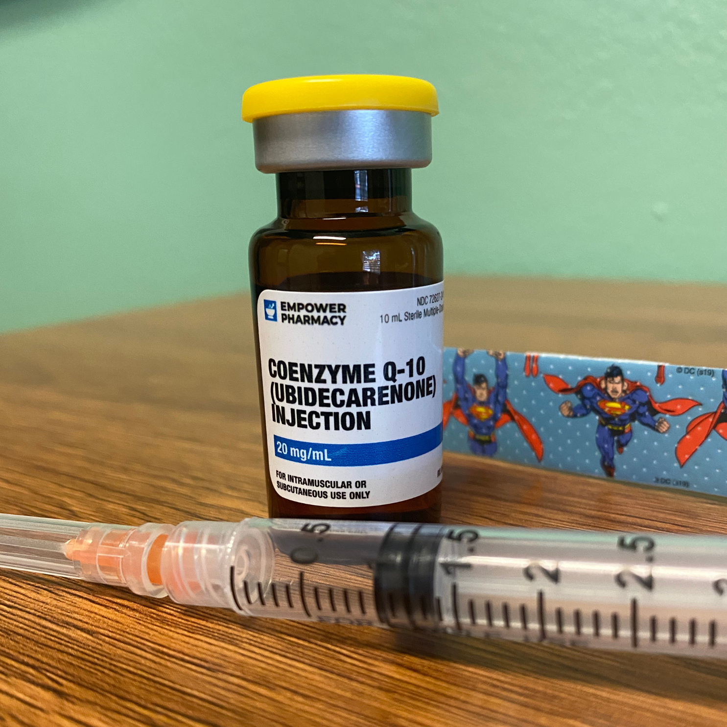 syringe beside a bottle of coenzyme q-10 injection