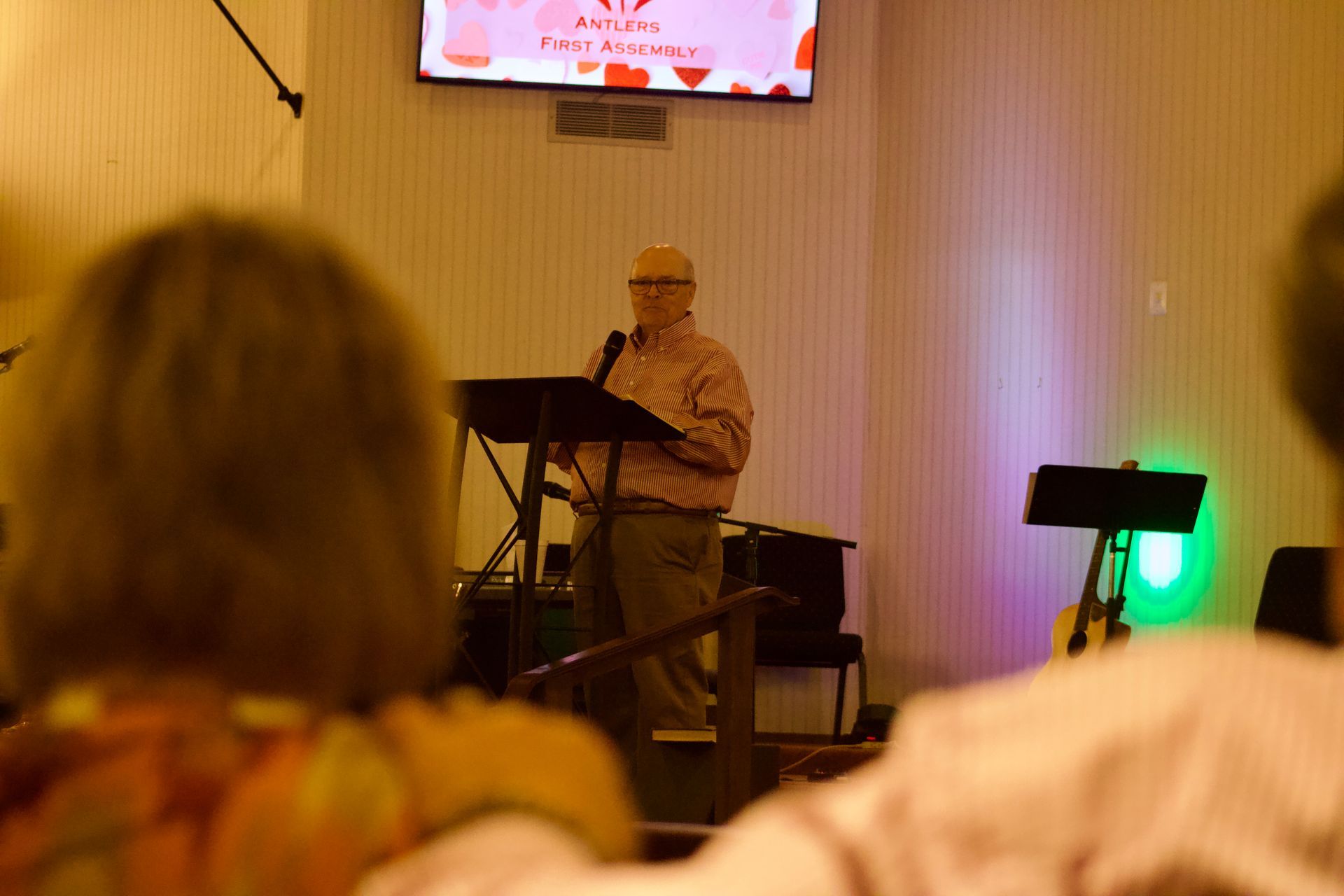 A man is standing at a podium giving a speech to a group of people.