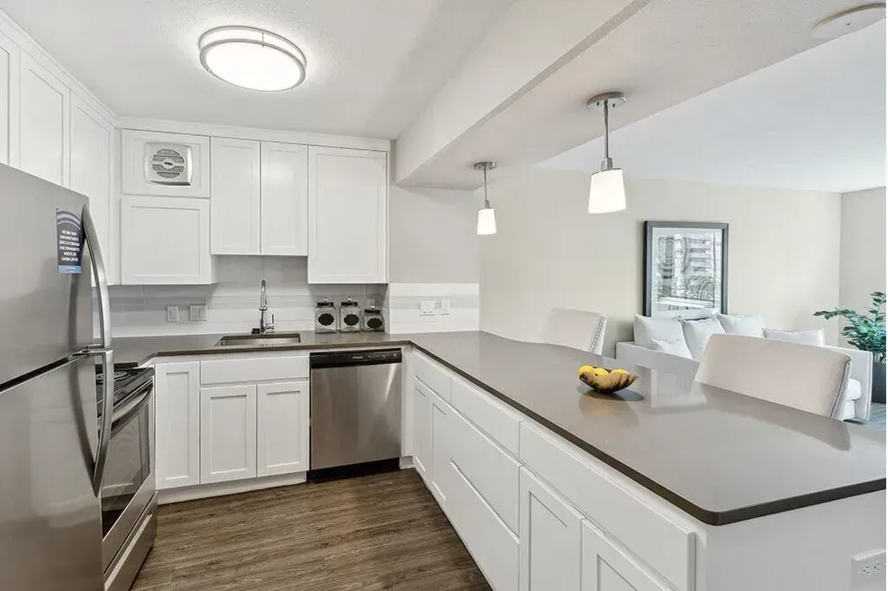 A kitchen with white cabinets and stainless steel appliances