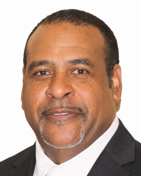 Headshot of a man in a dark suit and white shirt against a plain white background