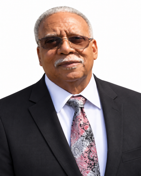 Portrait of a man in a black suit, white shirt, patterned tie, and sunglasses on a white background