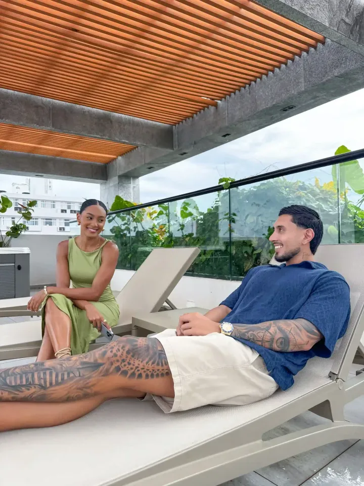 Pareja relajándose en el rooftop del Delamar Hotel San Andrés, disfrutando de vista al mar y ambiente romántico para vacaciones en pareja.