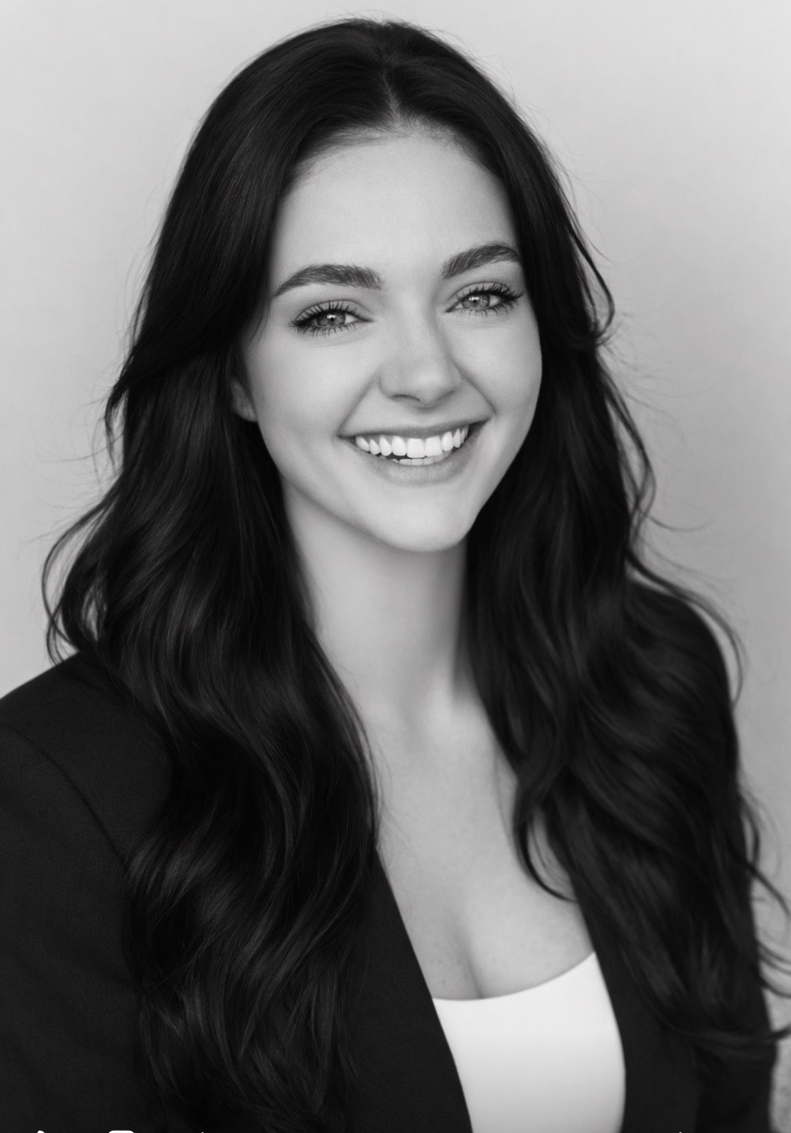 Black-and-white portrait of a smiling woman with long dark hair against a plain background - ev law in Bundall, QLD