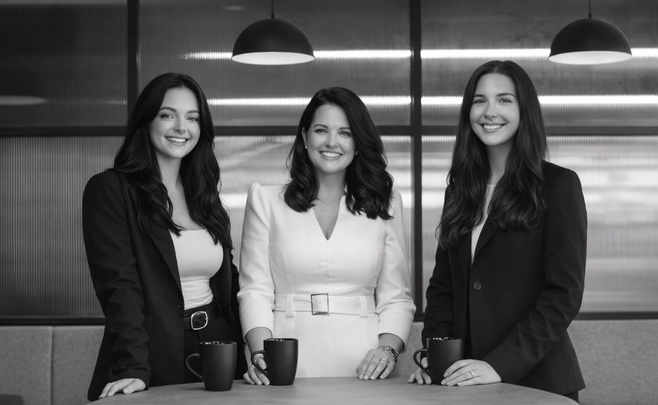 Three people smiling behind a counter in a modern office space - ev law in Bundall, QLD
