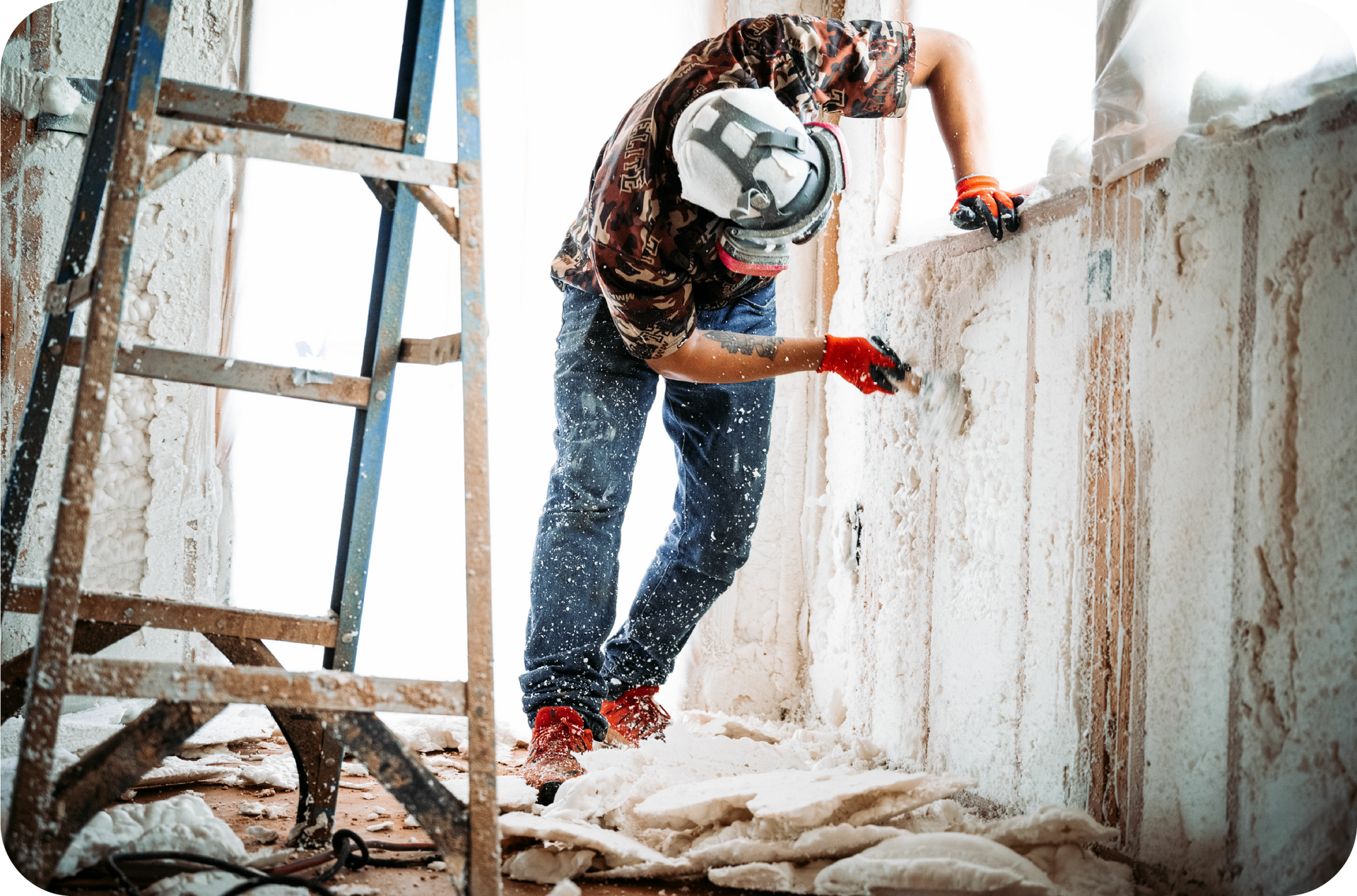 A man is working on the side of a building with a crane.