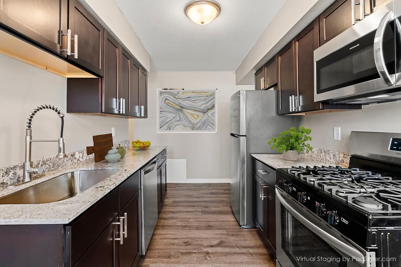 galley style kitchen with dark wood cabinets - Skyline Real Estate Services