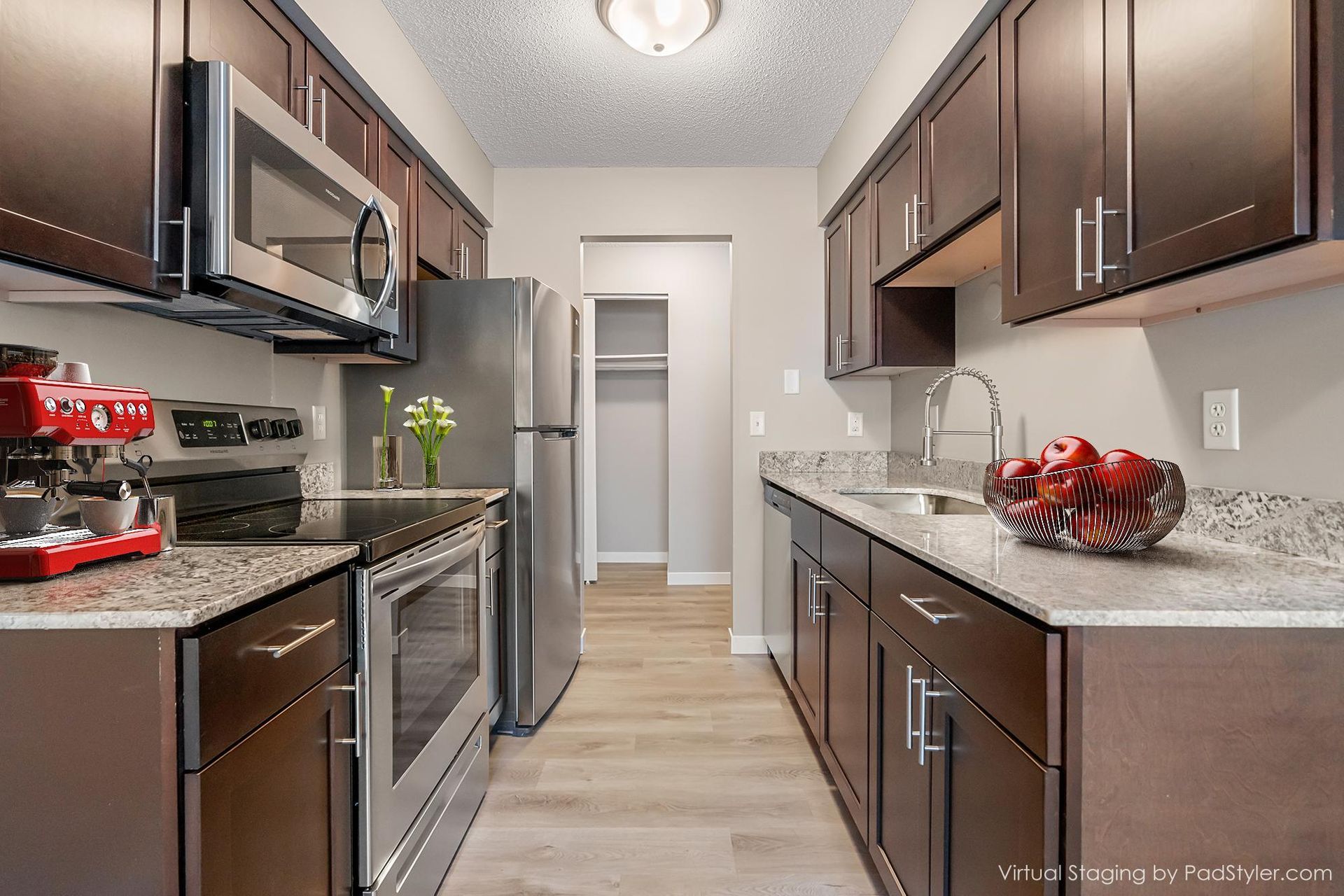apartment with a galley style kitchen and dark wood cabinets - Skyline Real Estate Services