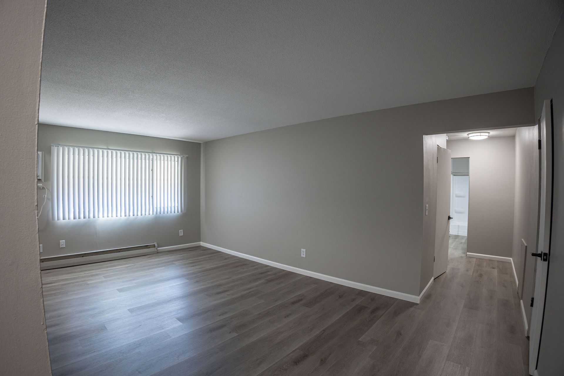 empty apartment with beige walls and lvp flooring - Skyline