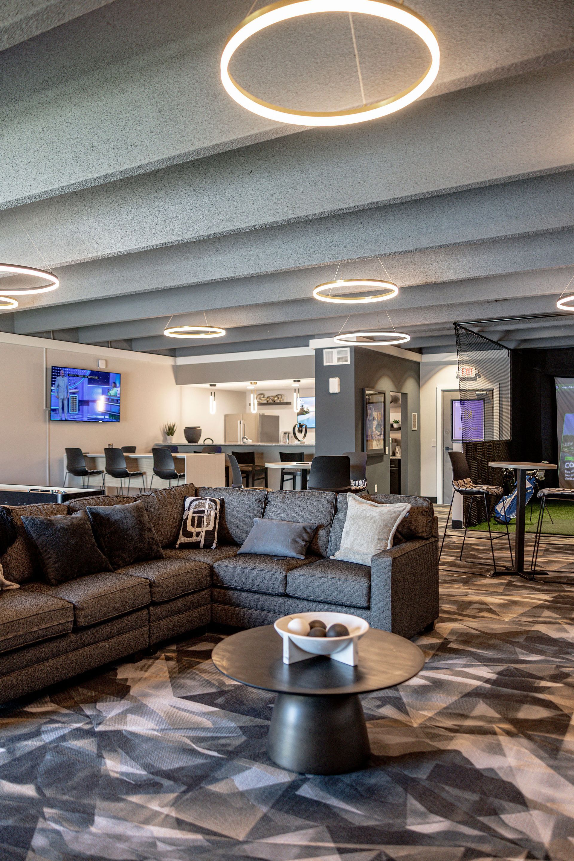 Modern hotel lounge with sectional sofa, round coffee table, and glowing circular ceiling lights