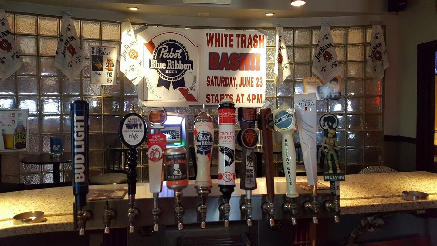 Bar with beer taps and a sign reading “White Trash” behind the counter