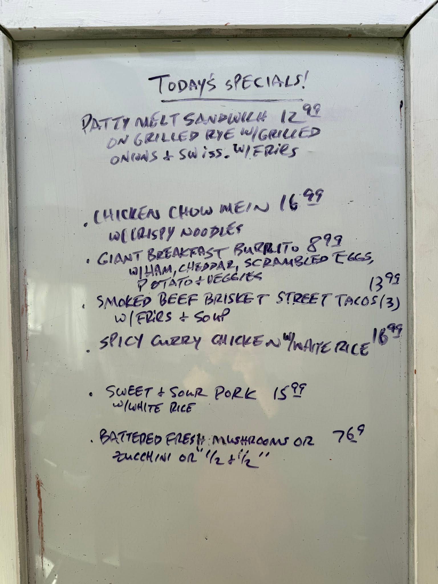 Handwritten weekly menu on a whiteboard, listing “Today’s Specials” and prices.